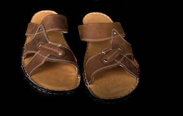 Leather summer sandals on a black background