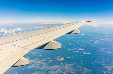 Fototapeta premium View from the airplane window at a beautiful cloudy sky and the airplane wing