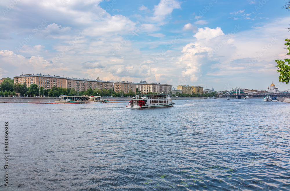 Wall mural Cruise ship sails on the Moscow river in Moscow city center, popular place for walking.