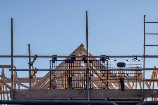 Newbuild house roof truss and scaffold. Residential construction industry image.