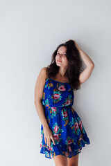 brunette in a floral dress on a white background
