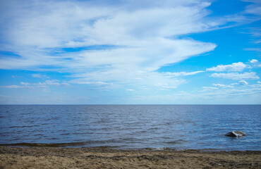 The Gulf of Finland in summer.White clouds over the water in summer.The horizon line above the waves.