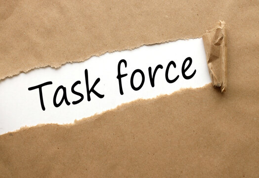 TASK FORCE . text on white paper on torn paper background