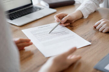 Business people discussing contract signing deal while sitting at the wooden table in office. Partners or lawyers working together at meeting. Teamwork, partnership, success concept.