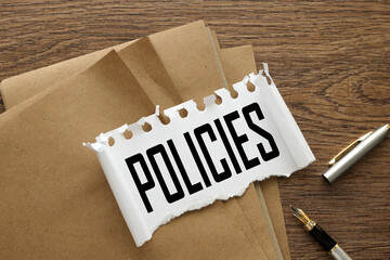 Policy torn paper with text on craft torn paper and pen pen