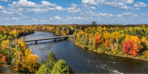 Fototapeta na wymiar Autumn colors on the river at Moosehead Lake, Maine - scenic drive