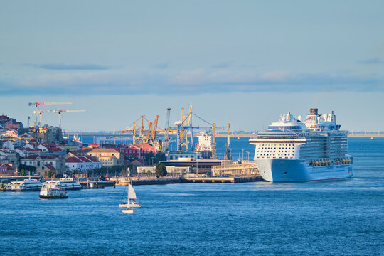 View of Lisbon over Tagus river from Almada with yachts tourist boats and cruise liner moored at cruise terminal at sunset. Lisbon, Portugal
