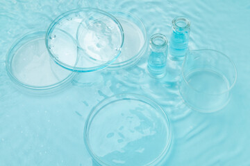Set of laboratory utensils empty Petri dish, flasks, jars on the background of blue water