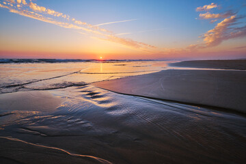 Atlantic ocean sunset with surging waves at Fonte da Telha beach, Costa da Caparica, Portugal