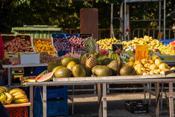 View of a street market of natural products, tables full of tropical fruits such as pineapples, bananas, melon, apples, oranges and a great variety of fresh fruits.