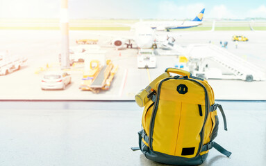 Yellow ruksak with cap and headphones in airport. Travel concept. Travel touristic concept. travel light