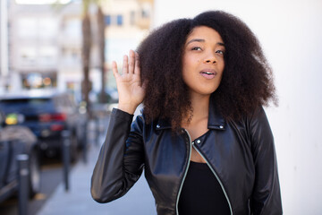 african american pretty woman looking serious and curious, listening, trying to hear a secret...