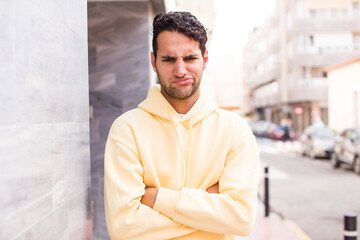 Obraz premium young hispanic man feeling displeased and disappointed, looking serious, annoyed and angry with crossed arms