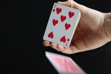 poker cards falling from a deck of cards holded by a hand