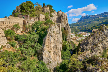 Fototapeta na wymiar Guadalest Castle on top of a rock with a bright blue sky