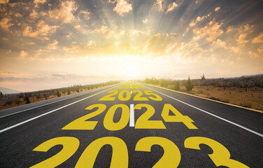 The word 2024 to 2028 written on highway road in the middle of empty asphalt road at golden sunrise. New year 2024 concept. Concept of planning and challenge, business strategy, new life change - obrazy, fototapety, plakaty