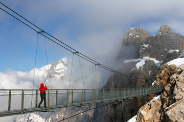 Tourist on the skywalk rope bridge in Dachstein Mountains, Austria, Europe