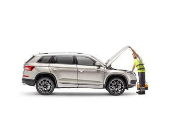 Road assistance worker repairing a vehicle with an open hood