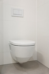 Fototapeta na wymiar White toilet bowl near light wall in room