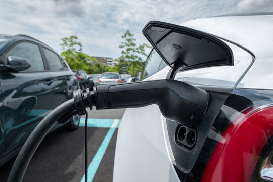 Abastecimento de um carro el&eacute;trico com a fonte de alimenta&ccedil;&atilde;o conectada &agrave; viatura num posto de servi&ccedil;o para carros el&eacute;tricos