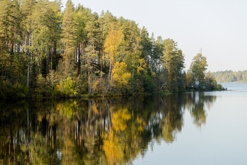 Autumn colorful foliage with lake reflection.Cloudy sky over autumn lake.forest river nature landscape