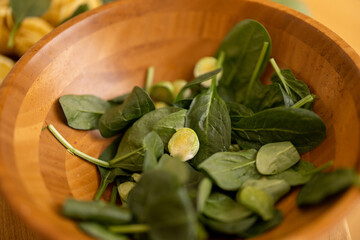 Spinach leaves in wooden bowl, close-up