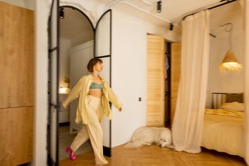 Stylish studio apartment interior in beige tones with a motion blurred female figure walking