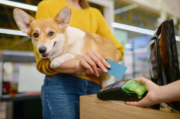 Closeup woman paying for purchase at pet shop using credit card
