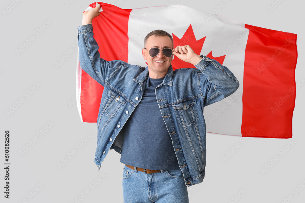 Canvas Prints Mature man with flag of Canada on light background