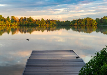 Sunset panorama of the lake shore of the Mere with a perfect lake reflection in Ellesmere in...