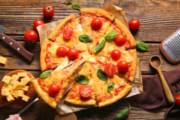 Baking paper with tasty pizza margarita on wooden table
