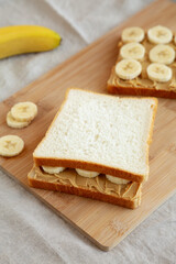 Fototapeta na wymiar Homemade Peanut Butter Banana Sandwich on a Bamboo Board, side view.
