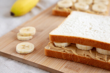 Homemade Peanut Butter Banana Sandwich on a Bamboo Board, side view. Close-up.