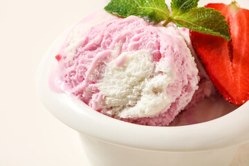 Bowl of strawberry ice cream with mint on white background, closeup