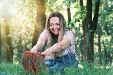 Portrait of a beautiful elderly woman doing exercises. Portrait of fit mature woman smiling on park...