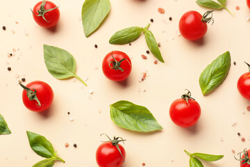 Composition with ripe cherry tomatoes, basil leaves, sea salt and peppercorn on beige background
