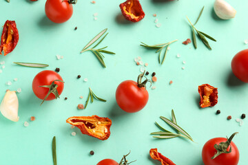 Composition with ripe cherry tomatoes, rosemary and dried pepper on turquoise background