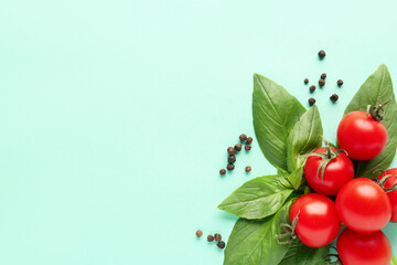 Composition with ripe cherry tomatoes, basil leaves and peppercorn on turquoise background