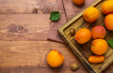 Board with fresh apricots on wooden table