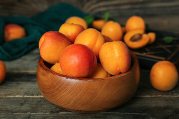 Bowl with fresh apricots on wooden table