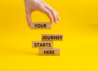 Your Journey starts here symbol. Concept word. Your Journey starts here on wooden blocks. Beautiful yellow background. Businessman hand. Business and Your Journey starts here concept. Copy space