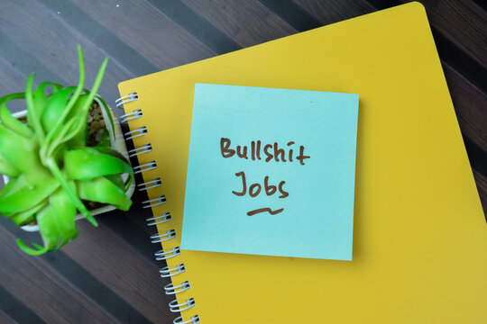 Concept of Bullshit Jobs write on sticky notes isolated on Wooden Table.