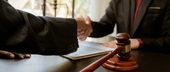 Businessman shaking hands to seal a deal with his partner lawyers or attorneys discussing a contract agreement.Legal law, advice, and justice concept