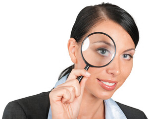 Businesswoman looking through a magnifying glass