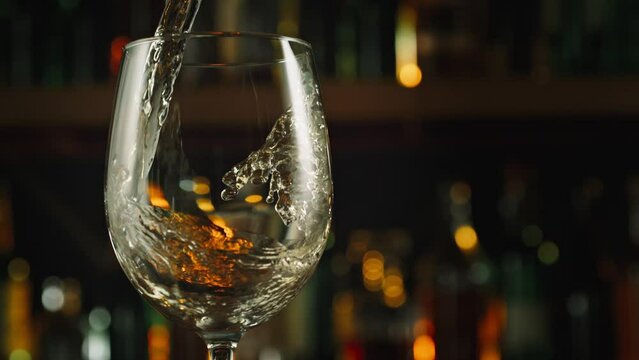 Super Slow Motion Shot of Pouring White Wine into Glass Before Bar at 1000fps.