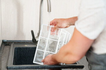 A man flushes the air cleaner filter from the air conditioner.