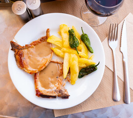 Tasty grilled pork meat served with traditional spanish sauce allioli, crispy french fries and...