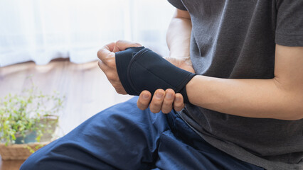 手首・親指のサポーターをする男性