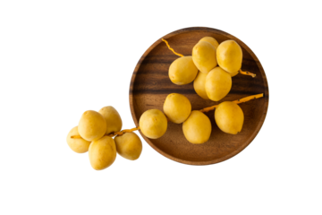 Ripe yellow dates bunches on wooden plate isolated on white