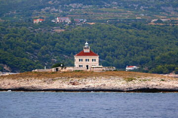 Fototapeta na wymiar Picturesque stone lighthouse on a tiny island near Hvar, Croatia.